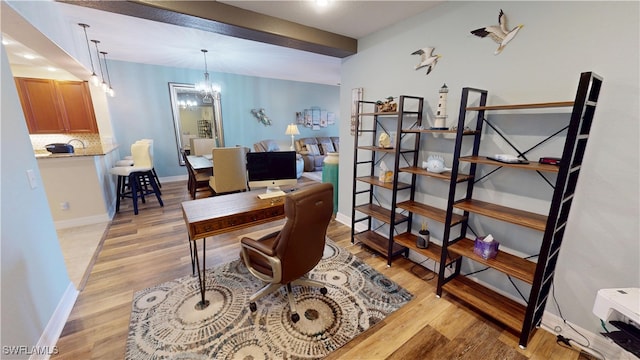 office area featuring baseboards, a chandelier, and light wood-style floors