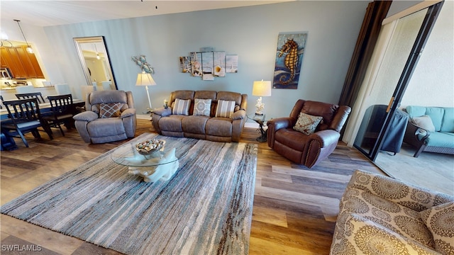 living area with baseboards and wood finished floors