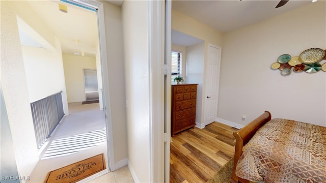 hall with baseboards and light wood finished floors