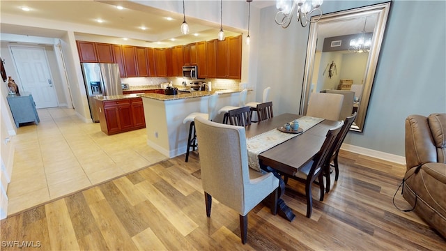 dining space featuring an inviting chandelier, recessed lighting, light wood-style flooring, and baseboards