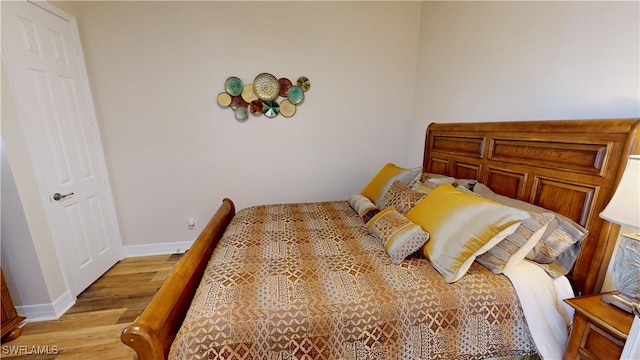 bedroom featuring baseboards and light wood finished floors
