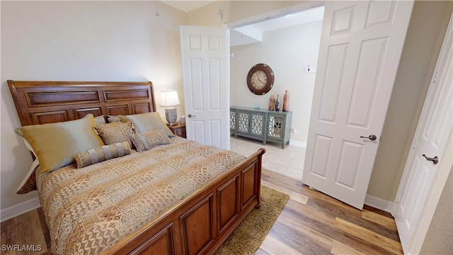 bedroom featuring light wood-style floors and baseboards