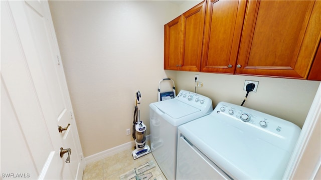 laundry room with cabinet space, light tile patterned flooring, baseboards, and washer and dryer