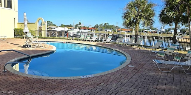 pool with a patio and fence