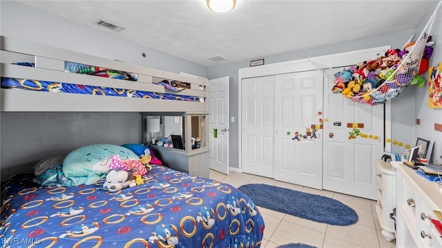 bedroom with light tile patterned floors, a closet, and visible vents