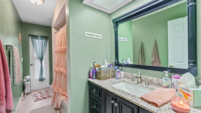 full bath with vanity, a shower with shower curtain, and a skylight