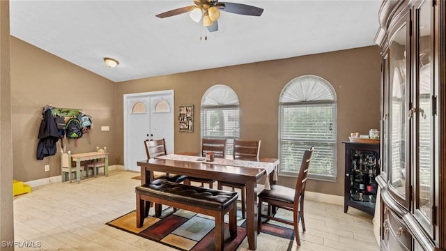 dining area with baseboards, a ceiling fan, and light wood-style flooring