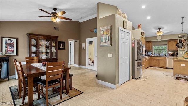 dining room with ceiling fan, visible vents, vaulted ceiling, light wood-type flooring, and baseboards