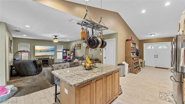 kitchen featuring visible vents, freestanding refrigerator, lofted ceiling, light wood-style floors, and ceiling fan