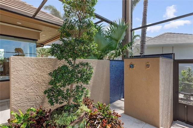view of side of property with a tile roof and stucco siding