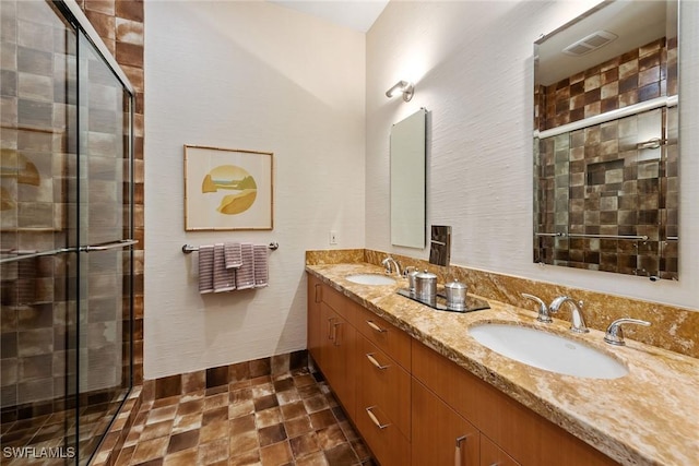 full bathroom featuring double vanity, visible vents, a shower stall, and a sink