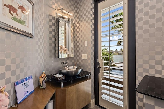 bathroom featuring decorative backsplash, tile walls, a wealth of natural light, and a sink