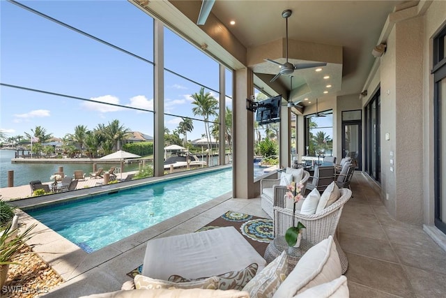 outdoor pool featuring an outdoor hangout area, a patio, ceiling fan, and a water view