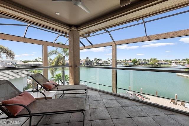 sunroom / solarium featuring a water view and ceiling fan