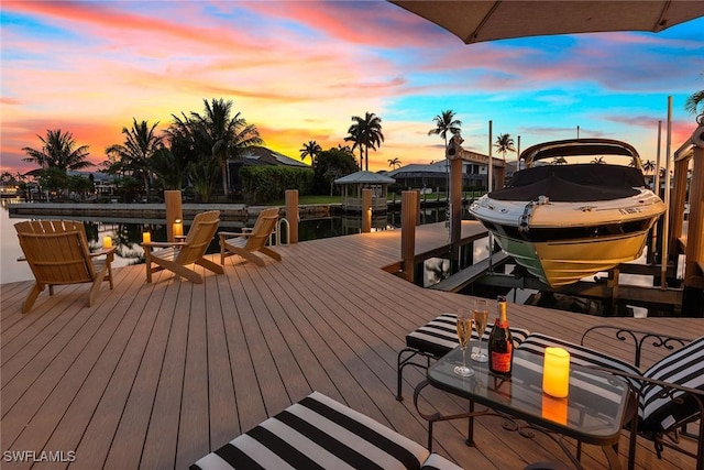 deck at dusk featuring a boat dock and boat lift