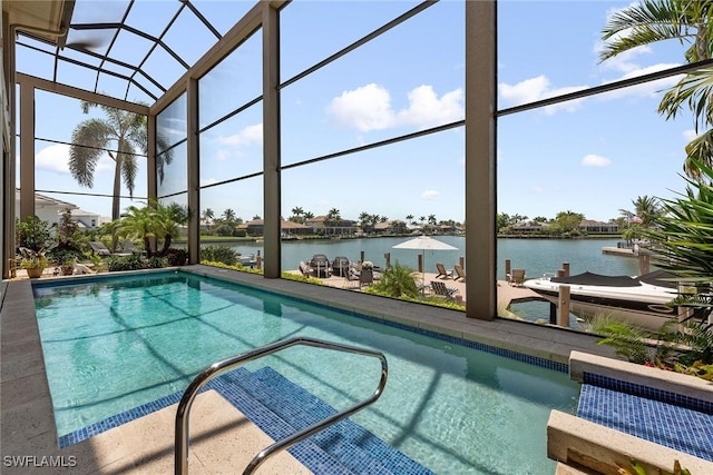 outdoor pool featuring glass enclosure, a water view, and a patio