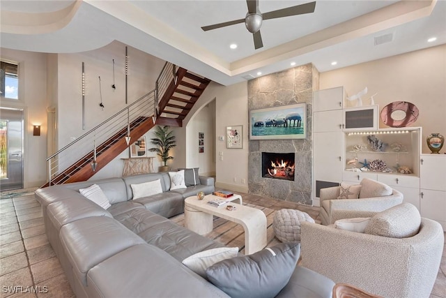 130 Hollyhock Ct, Marco Island, FL 34145 - living room with a ceiling fan, stairway, recessed lighting, a tiled fireplace, and a raised ceiling