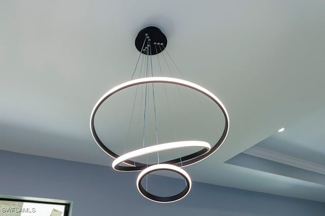 interior details featuring an inviting chandelier and ornamental molding
