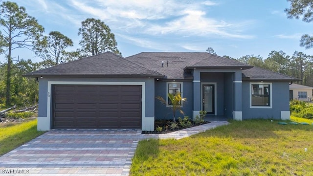 view of front of property featuring a garage, driveway, a front yard, and stucco siding