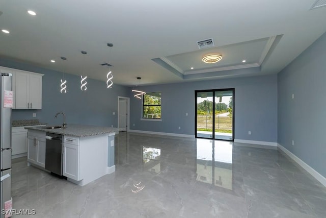 kitchen with a kitchen island with sink, baseboards, open floor plan, a tray ceiling, and appliances with stainless steel finishes