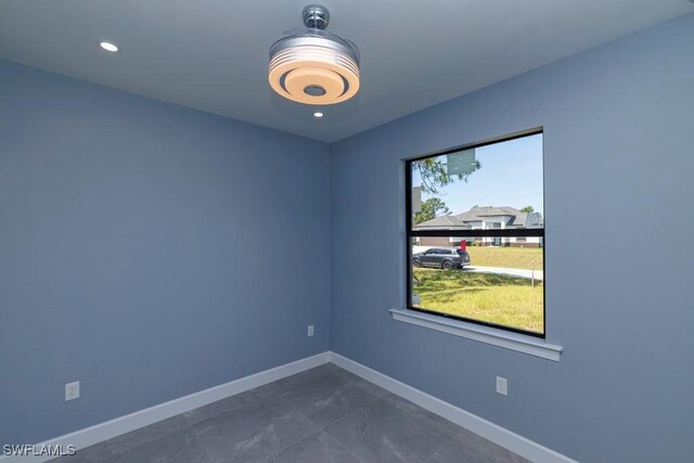 unfurnished room with baseboards
