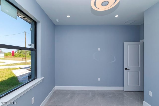 unfurnished room with baseboards, recessed lighting, and marble finish floor