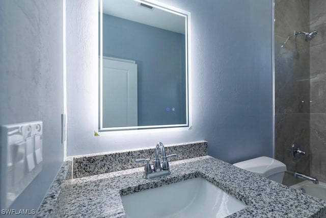bathroom with toilet, bathing tub / shower combination, and vanity