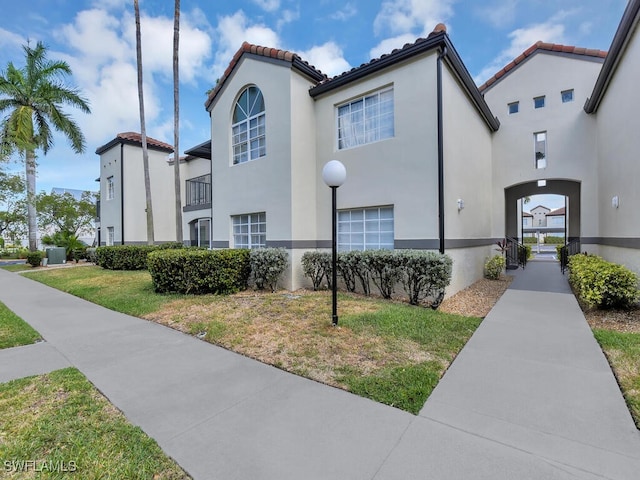 view of home's exterior featuring stucco siding, a yard, and a tile roof