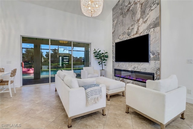 9680 Pineapple Preserve Ct, Fort Myers, FL 33908 - living area with tile patterned flooring, a fireplace, baseboards, a chandelier, and a high ceiling