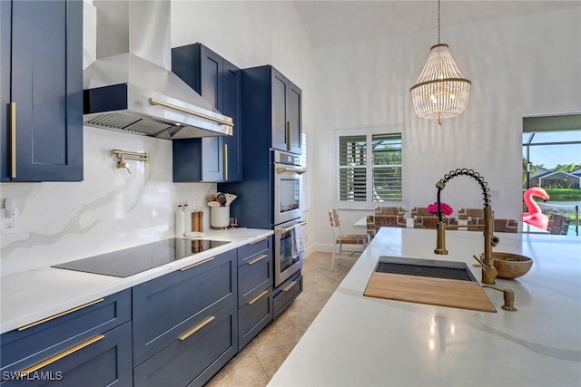 9680 Pineapple Preserve Ct, Fort Myers, FL 33908 - kitchen featuring stainless steel double oven, black electric stovetop, hanging light fixtures, a chandelier, and wall chimney exhaust hood
