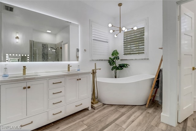 9680 Pineapple Preserve Ct, Fort Myers, FL 33908 - bathroom with visible vents, a stall shower, wood finished floors, a sink, and an inviting chandelier