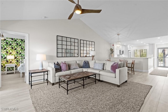 living area featuring high vaulted ceiling, light wood-style flooring, a ceiling fan, baseboards, and recessed lighting