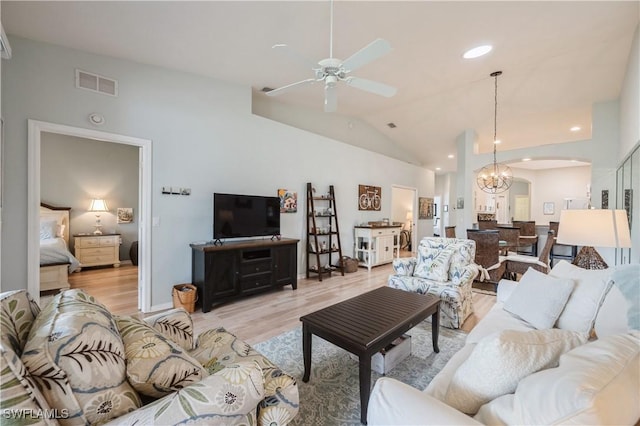 6171 Mandalay Cir Unit 28, Naples, FL 34112 - living area with visible vents, light wood-style floors, arched walkways, ceiling fan with notable chandelier, and vaulted ceiling