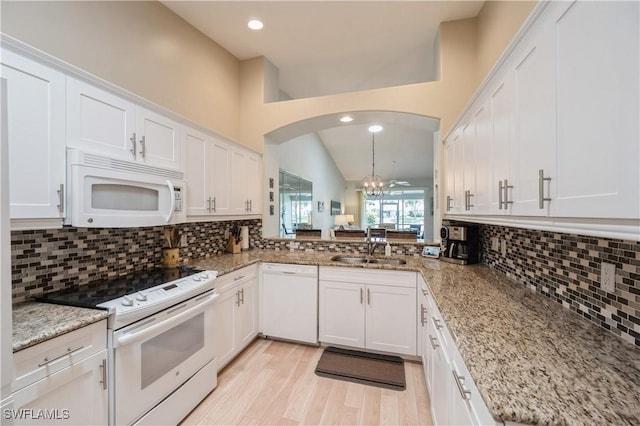 6171 Mandalay Cir Unit 28, Naples, FL 34112 - kitchen featuring decorative backsplash, a notable chandelier, white cabinets, and white appliances