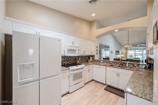 6171 Mandalay Cir Unit 28, Naples, FL 34112 - kitchen with visible vents, decorative backsplash, white appliances, arched walkways, and a sink