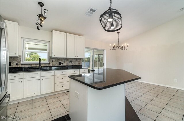 2727 SW 18th Pl, Cape Coral, FL 33914 - kitchen with light tile patterned floors, visible vents, backsplash, and white cabinetry