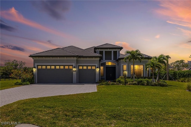 19720 Panther Island Blvd, Estero, FL 33928 - view of front of house featuring a garage, decorative driveway, stucco siding, and a yard