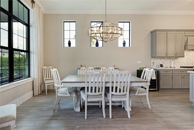 19720 Panther Island Blvd, Estero, FL 33928 - dining space with crown molding, an inviting chandelier, baseboards, beverage cooler, and wood finish floors