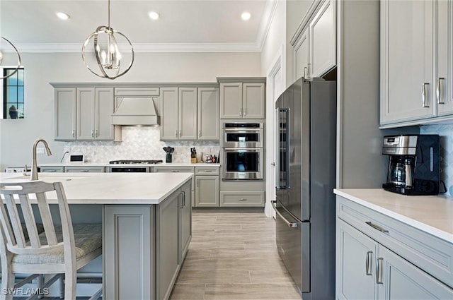 19720 Panther Island Blvd, Estero, FL 33928 - kitchen with gray cabinets, custom exhaust hood, stainless steel appliances, and backsplash