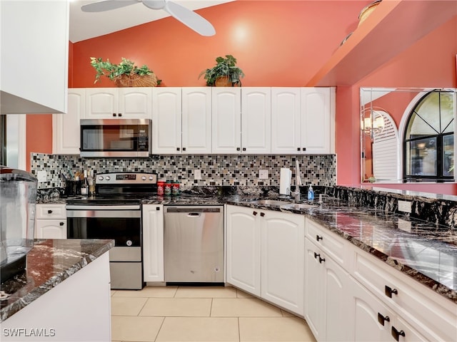 28796 Hunters Ct, Bonita Springs, FL 34135 - kitchen with stainless steel appliances, dark stone countertops, light tile patterned flooring, and white cabinetry