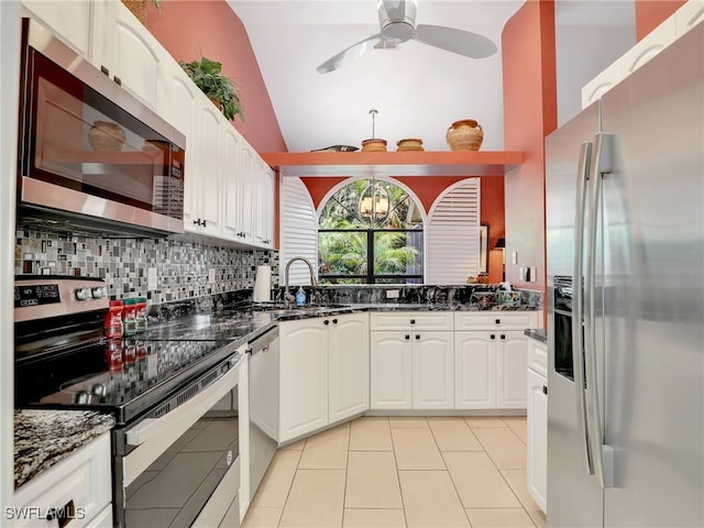 28796 Hunters Ct, Bonita Springs, FL 34135 - kitchen featuring dark stone counters, white cabinetry, a sink, backsplash, and stainless steel appliances