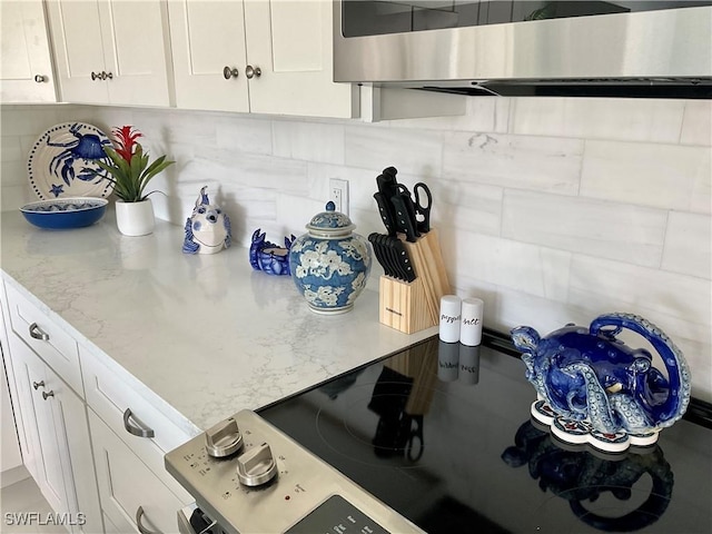 1618 Forest Lakes Blvd, Naples, FL 34105 - kitchen featuring white cabinets, light stone counters, wall chimney exhaust hood, and decorative backsplash