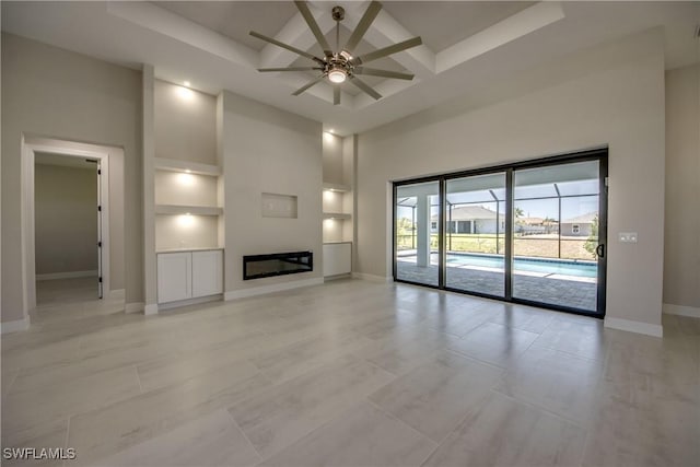 10 NW 13th Pl, Cape Coral, FL 33993 - unfurnished living room with built in features, a towering ceiling, baseboards, ceiling fan, and coffered ceiling