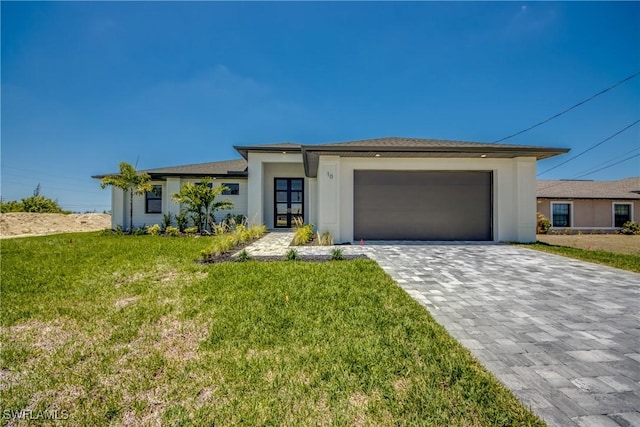 10 NW 13th Pl, Cape Coral, FL 33993 - prairie-style house featuring an attached garage, decorative driveway, a front lawn, and stucco siding