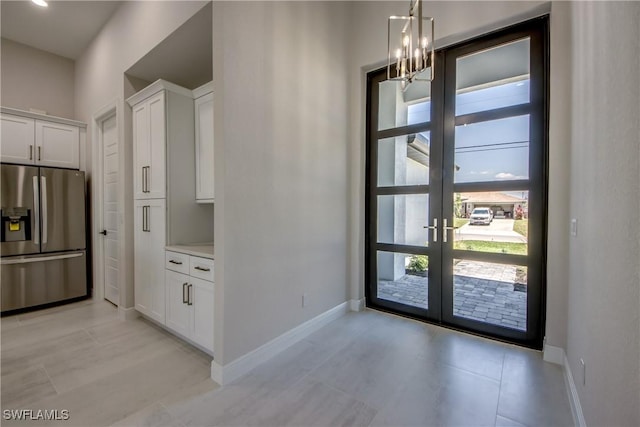 10 NW 13th Pl, Cape Coral, FL 33993 - interior space featuring light tile patterned floors, baseboards, french doors, and a chandelier