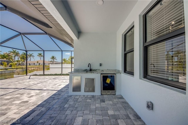 10 NW 13th Pl, Cape Coral, FL 33993 - view of patio featuring beverage cooler, a sink, a lanai, and an outdoor kitchen