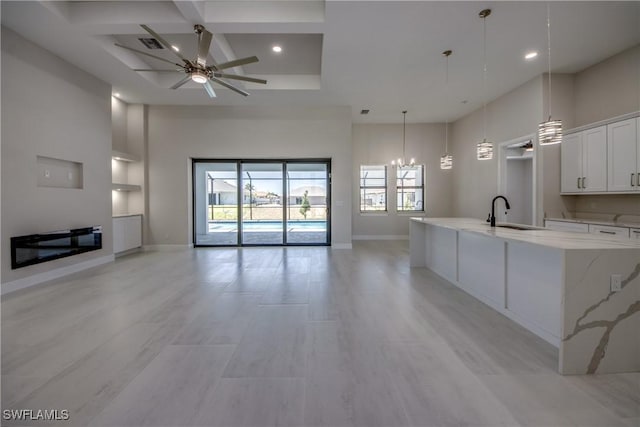 10 NW 13th Pl, Cape Coral, FL 33993 - unfurnished living room featuring a sink, ceiling fan with notable chandelier, recessed lighting, baseboards, and coffered ceiling