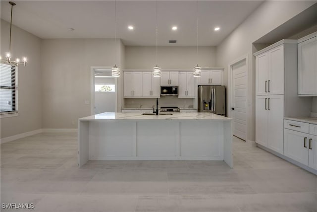 10 NW 13th Pl, Cape Coral, FL 33993 - kitchen with a healthy amount of sunlight, a kitchen island with sink, stainless steel appliances, and white cabinetry