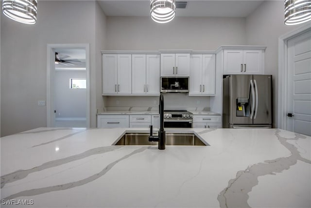 10 NW 13th Pl, Cape Coral, FL 33993 - kitchen with pendant lighting, appliances with stainless steel finishes, white cabinets, and a sink