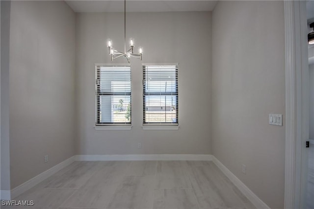 10 NW 13th Pl, Cape Coral, FL 33993 - spare room featuring baseboards and a notable chandelier